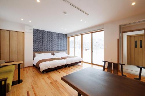 a bedroom with a bed and a table in it at Hakuba Highland Hotel in Hakuba