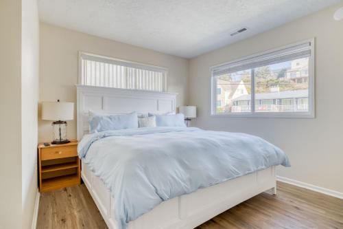 a white bedroom with a bed and a window at Casa de Navarro in Lincoln City