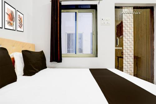 a bedroom with a white bed with a window at Indian Hotel in Bareilly