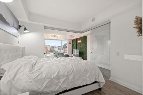 a white bedroom with a large bed and a window at Luxurious Suite in Yorkville in Toronto