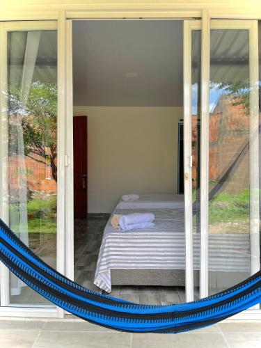 a hammock in a room with a bed and a window at Tu hogar en Tauramena in Tauramena