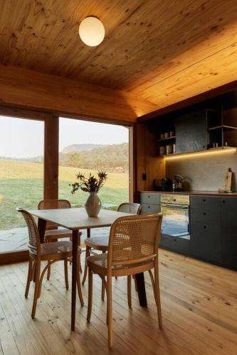 a kitchen and dining room with a table and chairs at Dimensions X Farm-stay at Krinklewood Estate in Broke