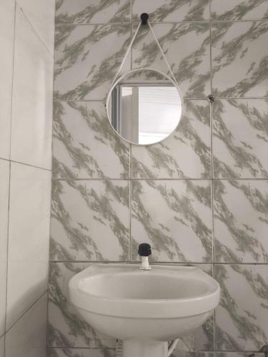 a bathroom with a sink and a mirror at Temporada Peterle | Casa vista mar Irirí in Anchieta
