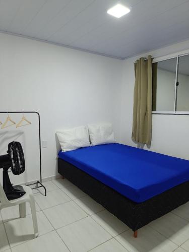 a bedroom with a blue bed and a chair at Temporada Peterle | Casa vista mar Irirí in Anchieta