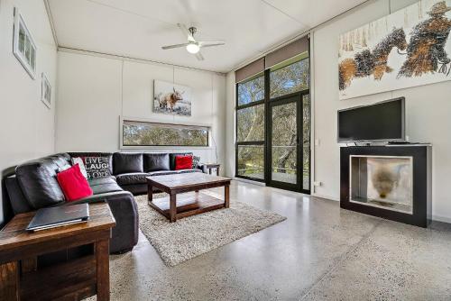 a living room with a couch and a tv at Ecocrackenback 13 Sustainable chalet. Stay 3, Pay 2 Summer 2026 in Crackenback