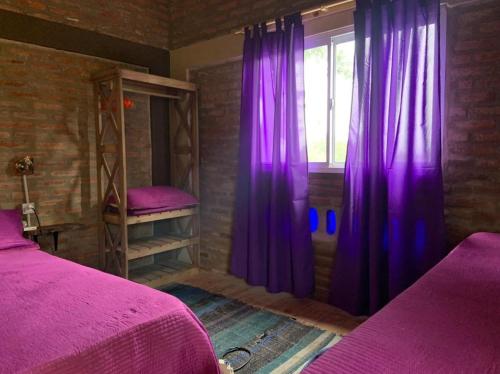 圣罗莎卡拉穆奇塔县Bauha Mini Apart的一间卧室配有紫色窗帘和窗户