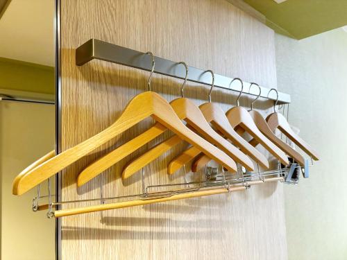 a rack of wooden utensils hanging on a wall at Hiyori Hotel Osaka Suminoekoen Station in Osaka