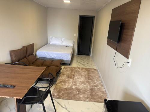 a small living room with a couch and a bed at Apartamento Moderno Novo 2025 in Passo Fundo