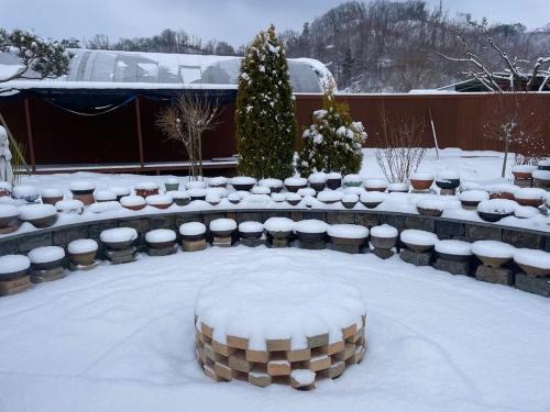 a garden covered in snow with a table and chairs at Sarah's Small Garden in Cheonan