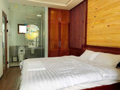 a bedroom with a white bed and a bathroom at NHỚ House IV in Da Lat
