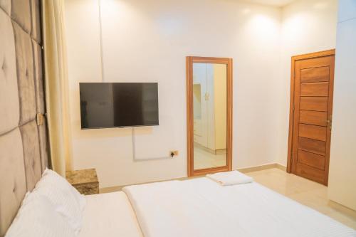 a bedroom with a bed with a television and a mirror at 4 BED Serene Living - Magodo Phase 1 - 247 POWER in Magodo