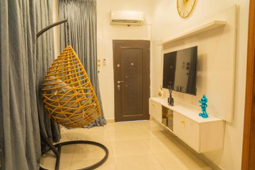 a living room with a television and a chair in a room at 4 BED Serene Living - Magodo Phase 1 - 247 POWER in Magodo