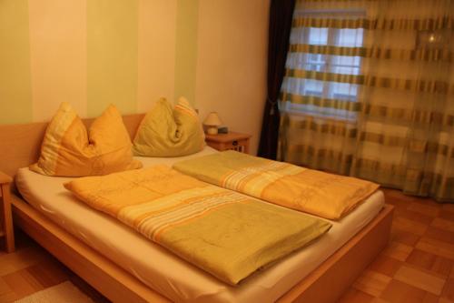 a bed with two pillows on top of it at Stadtappartements Oppeneiger in Radstadt