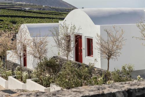 a white house with red windows and stairs at Vedema, a Luxury Collection Resort, Santorini in Megalokhori