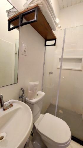 a bathroom with a white toilet and a sink at Villamar Pousada in Morro de São Paulo