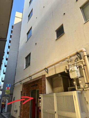 a red arrow is on the side of a building at 平和岛民宿 in Tokyo
