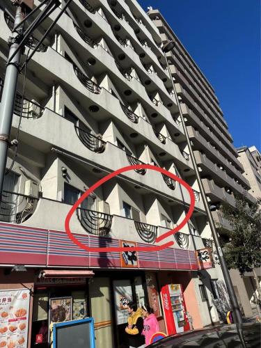 a tall building with a red circle on the side of it at 平和岛民宿 in Tokyo