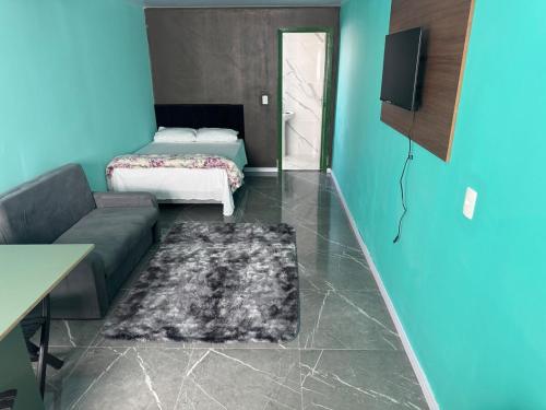 a living room with a couch and a bed at Flats e Residence - Apartamento novo in Passo Fundo