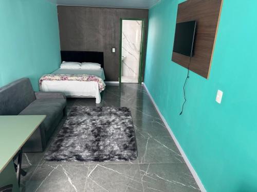 a living room with a couch and a bed at Flats e Residence - Apartamento novo in Passo Fundo