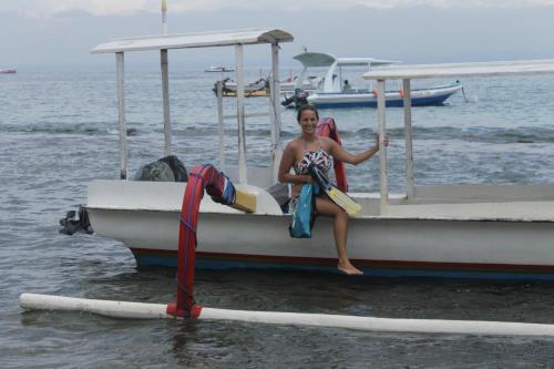 a woman sitting on a boat in the water at Breeze Villa in Nusa Lembongan