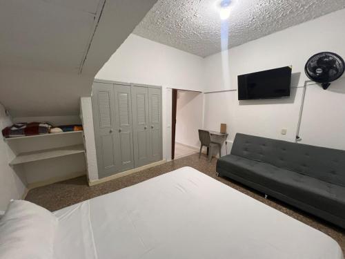 a bedroom with a couch and a tv in a room at Acogedor apartamento en Armenia in Armenia
