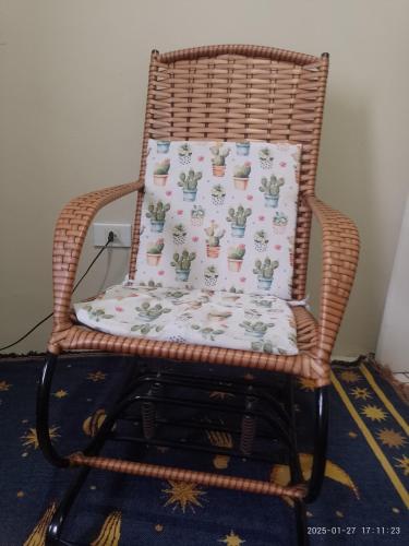 a wicker chair with a pillow on it at Vista para o mar e Farol de Olinda, Perto da FACULDADE DE MEDICINA DE OLINDA , Cama Solteiro Com colchão Adicional, Estante e Ventilador in Olinda