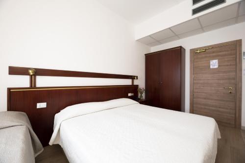 a bedroom with a large white bed and a closet at Hotel Vienna in Marghera