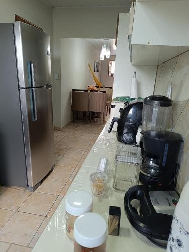 a kitchen with a counter top with a refrigerator at Casa aconchegante ao lado da Igreja Matriz- Bananeiras-PB in Bananeiras