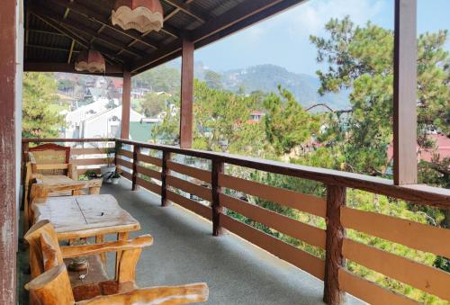 a balcony with tables and chairs and a view at RedDoorz @ Monterrazas Village Homestay Baguio in Baguio