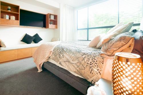 a bedroom with a bed and a large window at Luxury 3BR In Beautiful New Farm in Brisbane