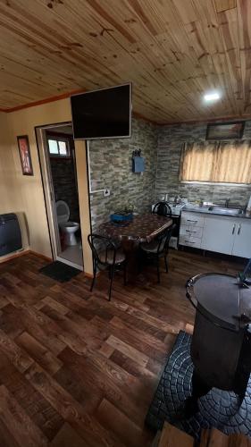 a living room with a table and a kitchen at alojamientos CM in Tolhuin