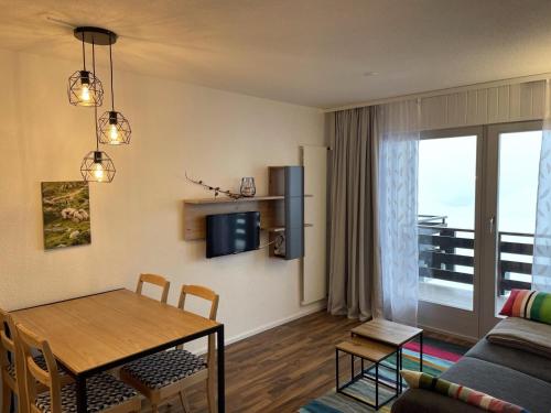 a living room with a table and a couch at Charming apartment with hill view in Veysonnaz