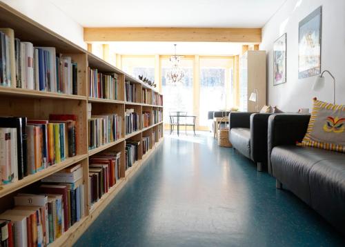 a living room with bookshelves filled with books at Shima-Davos in Davos
