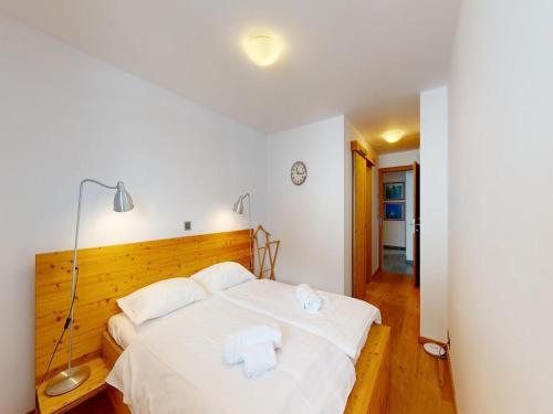 a bedroom with a white bed with two towels at Lush chalet in Heremence with sauna in Hérémence