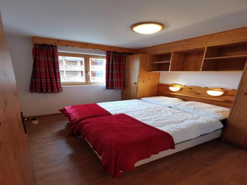 a bedroom with a large bed with a red blanket at Spacious apartment in Nendaz in Nendaz