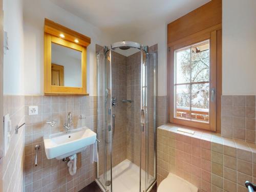 um banheiro com uma pia, um chuveiro e um espelho em Apartment in central location with views em Nendaz