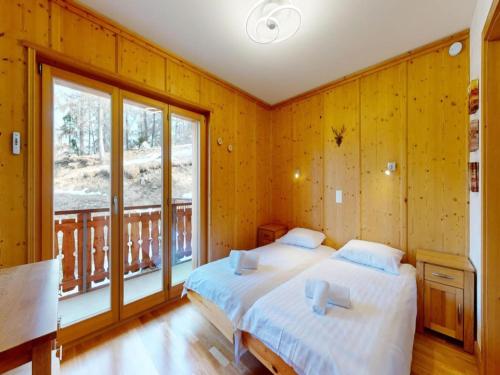 ヴェゾナにあるCentrally-located apartment for 6のベッドが2つと大きな窓がある寝室