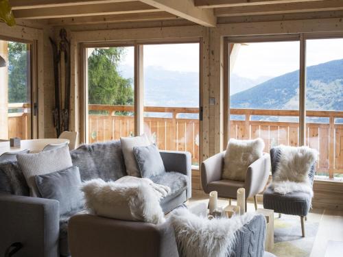 a living room with couches and chairs and large windows at Chalet in Les Masses with garden in Agettes