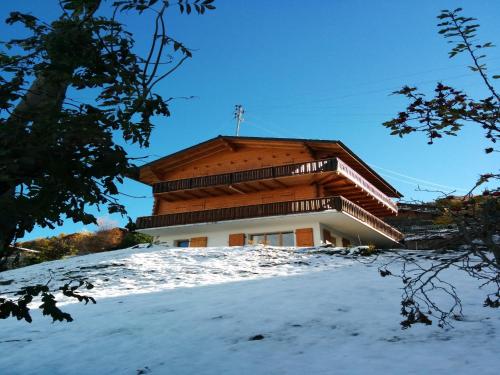 a building on top of a snow covered hill at Sunny apartment with outdoor dinning in Veysonnaz