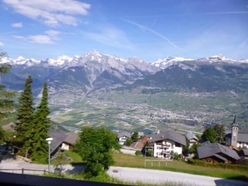 a view of a town with snow capped mountains at Sunny apartment with outdoor dinning in Veysonnaz