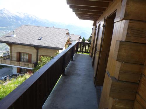 a balcony with a view of a house at Sunny apartment with outdoor dinning in Veysonnaz