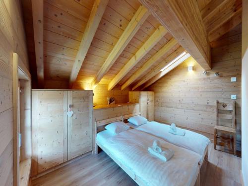 a bedroom with a bed in a wooden room at Nice apartment with balcony in Nendaz