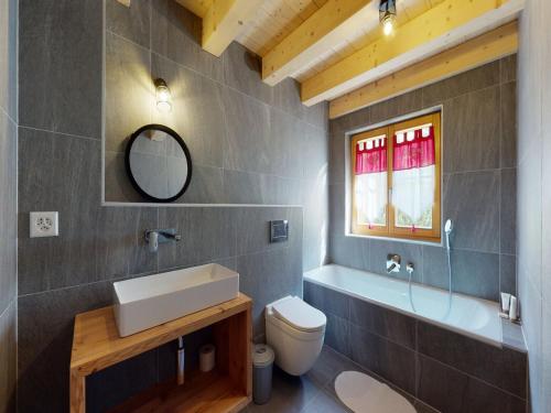 a bathroom with a sink and a toilet and a mirror at Nice apartment with balcony in Nendaz