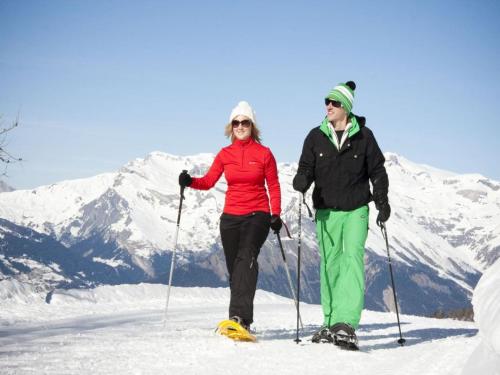 a man and a woman on skis in the snow at Chalet in Les Masses with garden in Agettes
