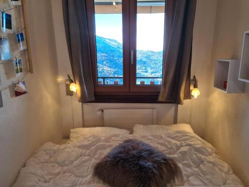 a white bed in a room with a window at Flat in Veysonnaz near Ski Lift & Valley Views in Veysonnaz