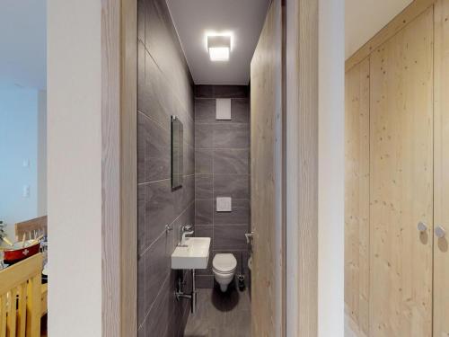 a bathroom with a white sink and a toilet at Pleasant apartment in Versonnaz in Veysonnaz