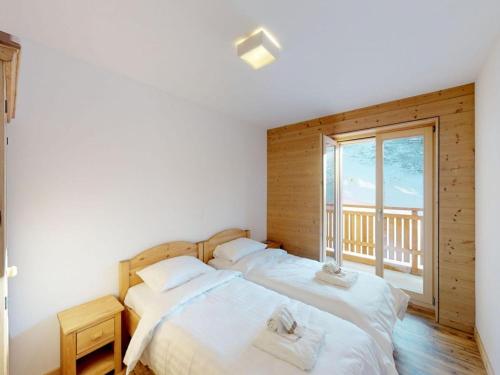 two beds in a room with a window at Pleasant apartment in Versonnaz in Veysonnaz