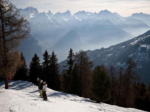 two people standing on top of a snow covered mountain at 3-bedroom apartment in Veysonnaz in Veysonnaz