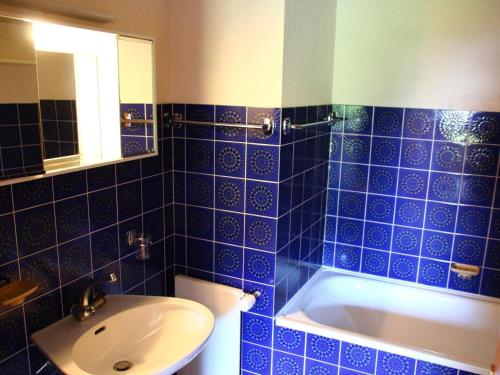 ヴェゾナにあるApartment, 250m from cable carの青いタイル張りのバスルーム(シンク、バスタブ付)