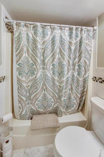 a bathroom with a shower curtain and a toilet at Bay's Place Vacation Rental in Lake Geneva